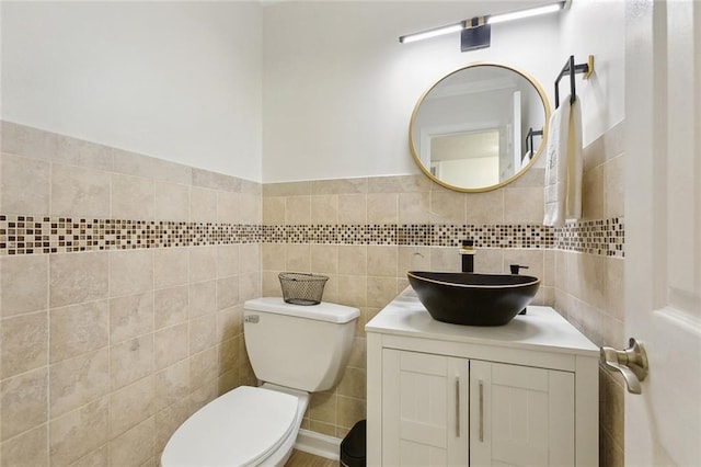 bathroom featuring toilet, tile walls, and vanity