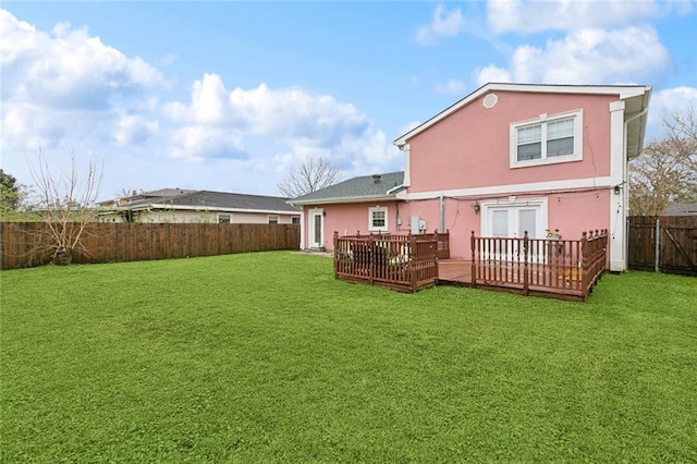 rear view of property with a fenced backyard, french doors, a lawn, a wooden deck, and stucco siding