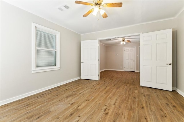 unfurnished room featuring light wood-type flooring, baseboards, visible vents, and ceiling fan