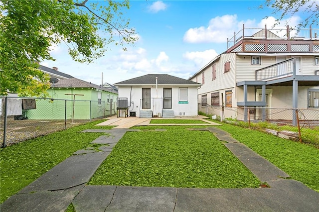 view of front facade featuring a front lawn, an outdoor structure, and fence private yard