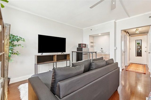 living room with dark wood-style floors, baseboards, ornamental molding, and a ceiling fan