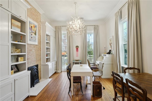 dining room featuring ornamental molding, a fireplace, and light wood-style floors