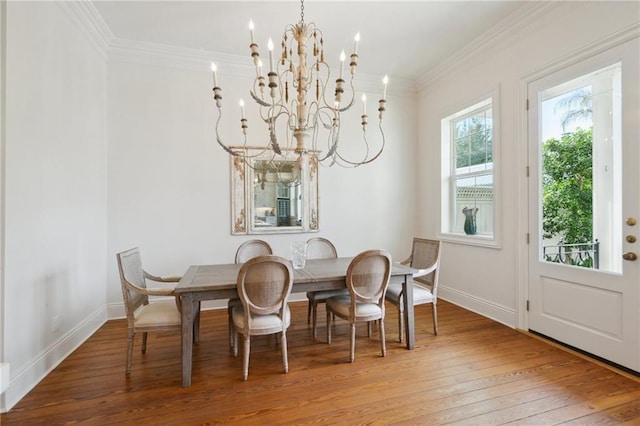 dining space with light wood-type flooring, baseboards, a chandelier, and crown molding