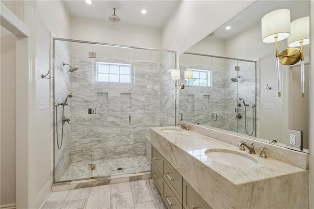 bathroom featuring marble finish floor, double vanity, a stall shower, and a sink