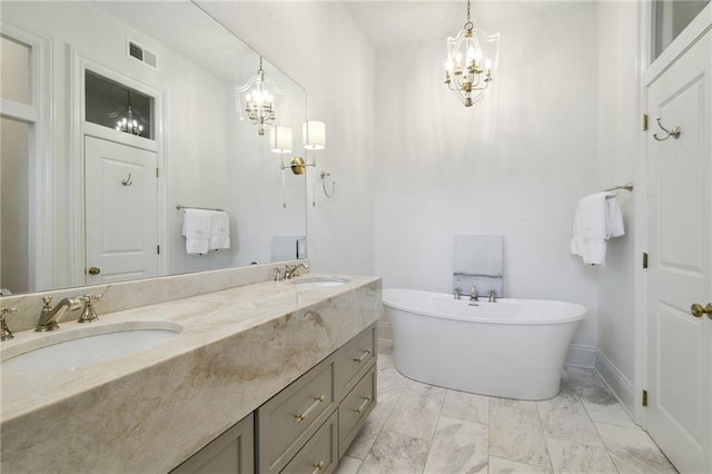 full bathroom featuring a freestanding bath, a sink, visible vents, and an inviting chandelier