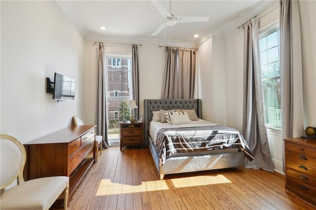 bedroom featuring ornamental molding, multiple windows, and wood finished floors