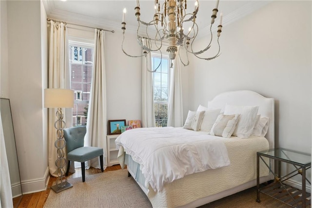 bedroom with ornamental molding, multiple windows, wood finished floors, and baseboards