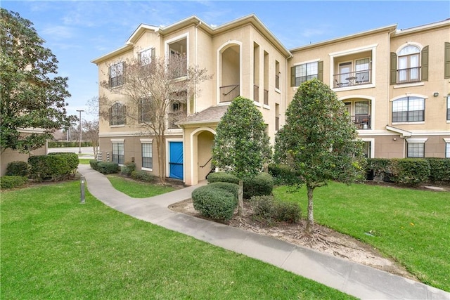 view of front of home featuring a front yard and stucco siding