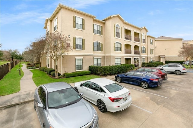 view of property featuring uncovered parking and fence