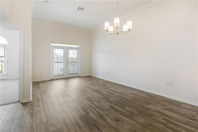 spare room featuring dark wood-type flooring, french doors, visible vents, and plenty of natural light