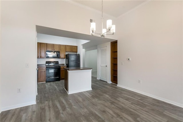 kitchen featuring pendant lighting, brown cabinets, dark countertops, ornamental molding, and black appliances