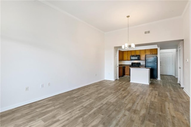 kitchen with visible vents, open floor plan, black appliances, brown cabinetry, and decorative light fixtures