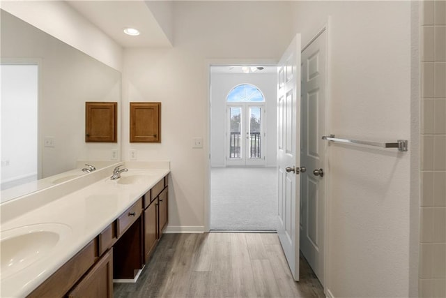 bathroom featuring double vanity, a sink, and wood finished floors