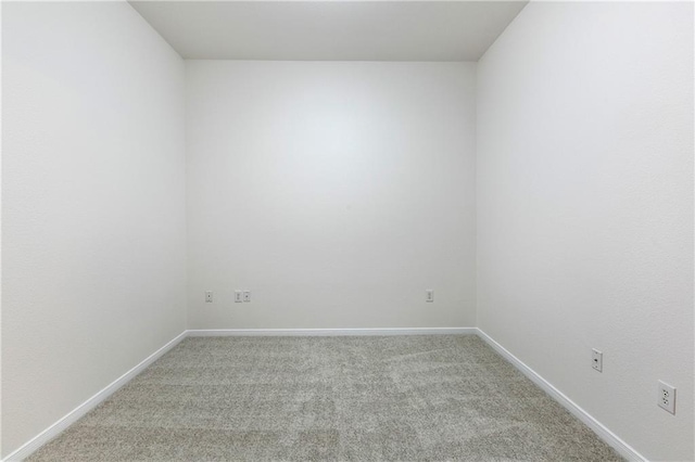 empty room featuring light carpet and baseboards