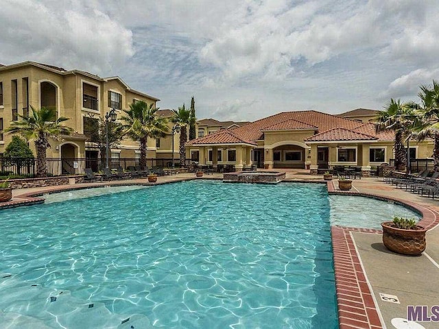 community pool with fence and a patio