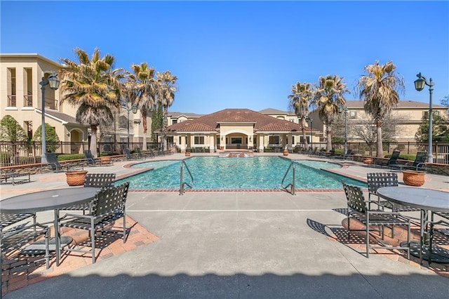 community pool featuring fence and a patio