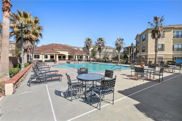 community pool with fence and a patio