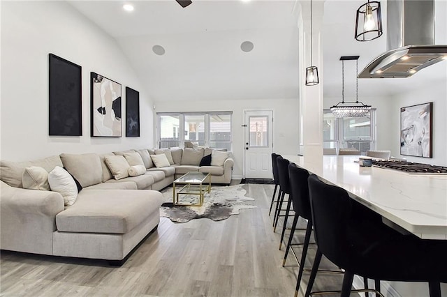 living area featuring light wood-type flooring, vaulted ceiling, and recessed lighting