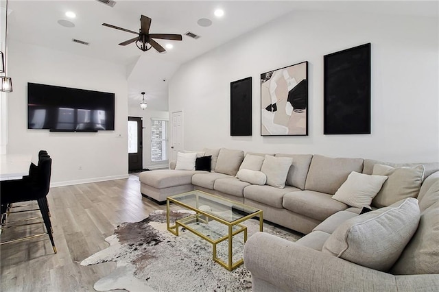 living area with vaulted ceiling, ceiling fan, wood finished floors, and visible vents