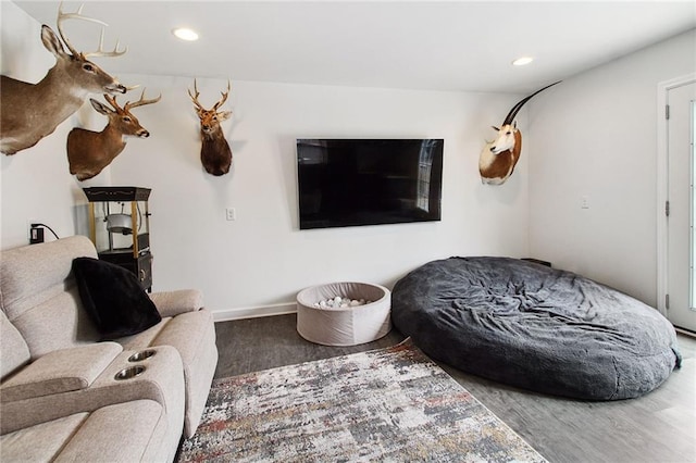 living area with baseboards, wood finished floors, and recessed lighting