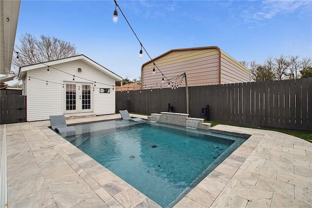 view of swimming pool with an exterior structure, a patio area, an outdoor structure, and a fenced backyard