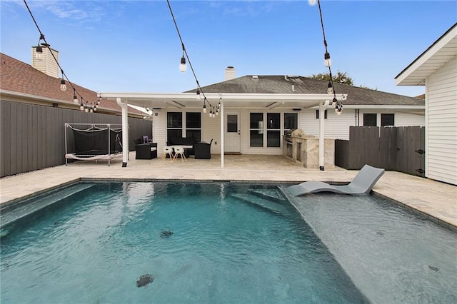 rear view of property with a fenced in pool, ceiling fan, a patio, and fence