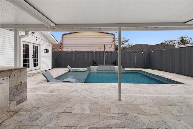 view of pool with a fenced backyard, a fenced in pool, a patio, and french doors