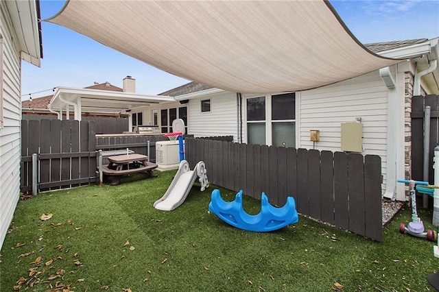 view of play area featuring a lawn and fence