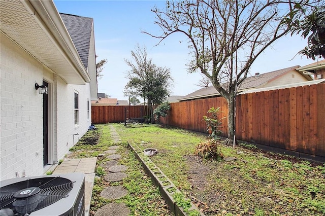 view of yard with a fenced backyard and central air condition unit