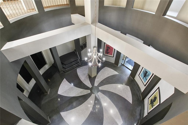 staircase with a chandelier and a towering ceiling