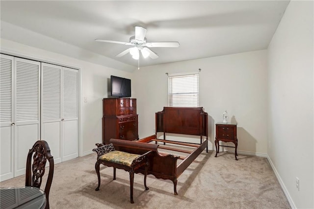 bedroom with a ceiling fan, a closet, light colored carpet, and baseboards