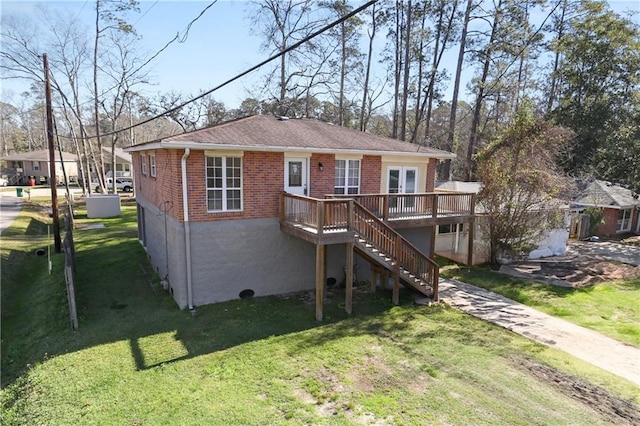 back of house with brick siding, a yard, stairway, and a wooden deck