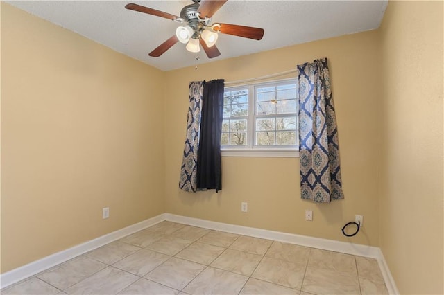 empty room with a ceiling fan, baseboards, and light tile patterned floors