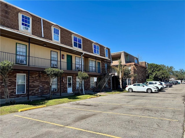 view of building exterior featuring uncovered parking and stairway