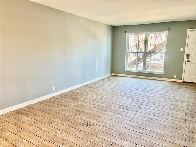 spare room with light wood-type flooring and baseboards