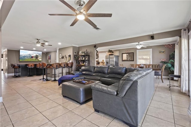 living area with a bar, visible vents, crown molding, and light tile patterned flooring