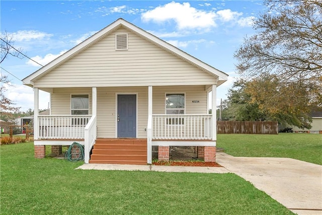 bungalow featuring covered porch, a front lawn, and fence