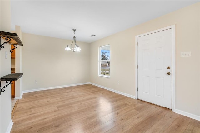 interior space featuring light wood-type flooring, baseboards, visible vents, and a chandelier