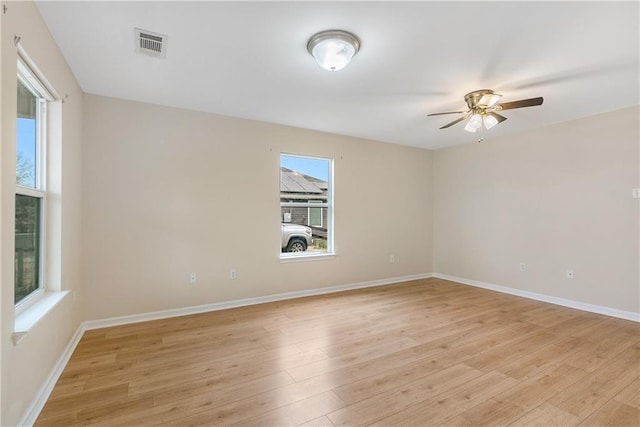 empty room with light wood-style floors, visible vents, ceiling fan, and baseboards