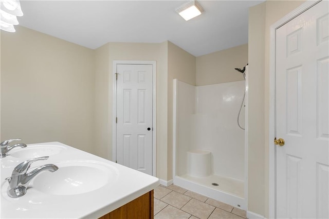 bathroom with a sink, a shower stall, and tile patterned floors