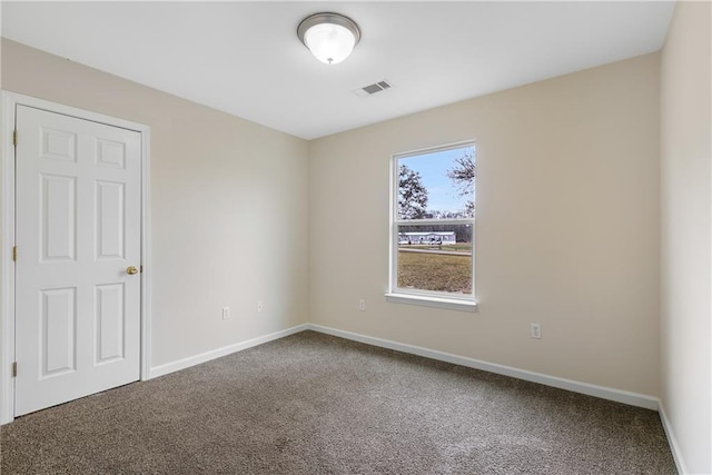 spare room featuring carpet flooring, visible vents, and baseboards