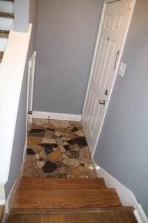 staircase with baseboards and wood finished floors