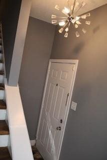 staircase with an inviting chandelier