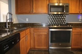 kitchen with stainless steel appliances, a sink, and brown cabinets