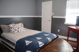 bedroom featuring a wainscoted wall