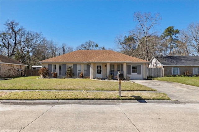 ranch-style home featuring fence, concrete driveway, and a front yard