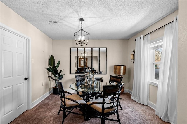 carpeted dining area featuring baseboards, visible vents, a chandelier, and a textured ceiling