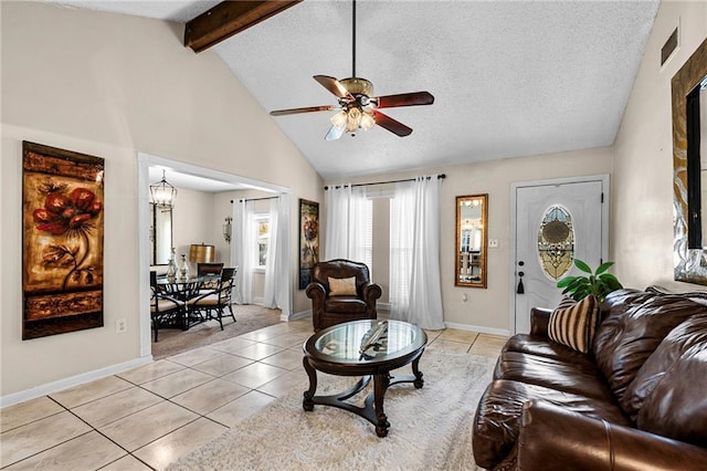 living room featuring beam ceiling, light tile patterned flooring, a textured ceiling, baseboards, and ceiling fan with notable chandelier