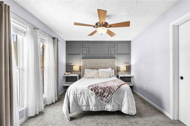 bedroom featuring light carpet, a ceiling fan, baseboards, and a textured ceiling