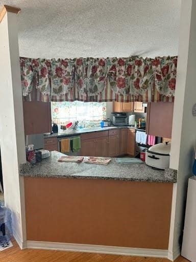 kitchen featuring dishwasher and a textured ceiling